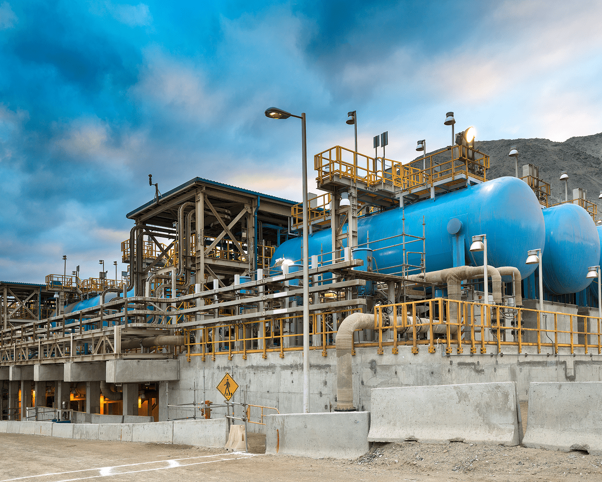Industrial facility with large blue storage tanks.